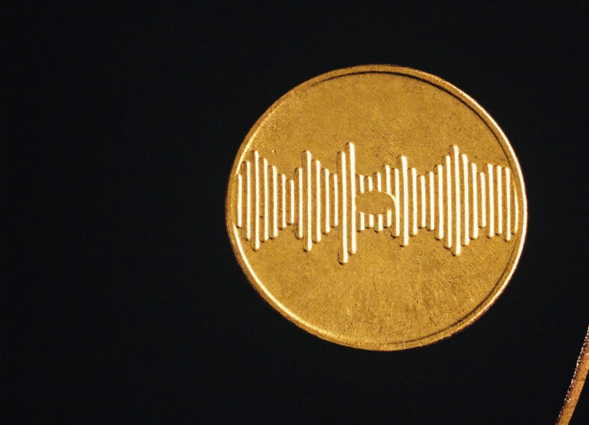 Gold token embossed with a soundwave