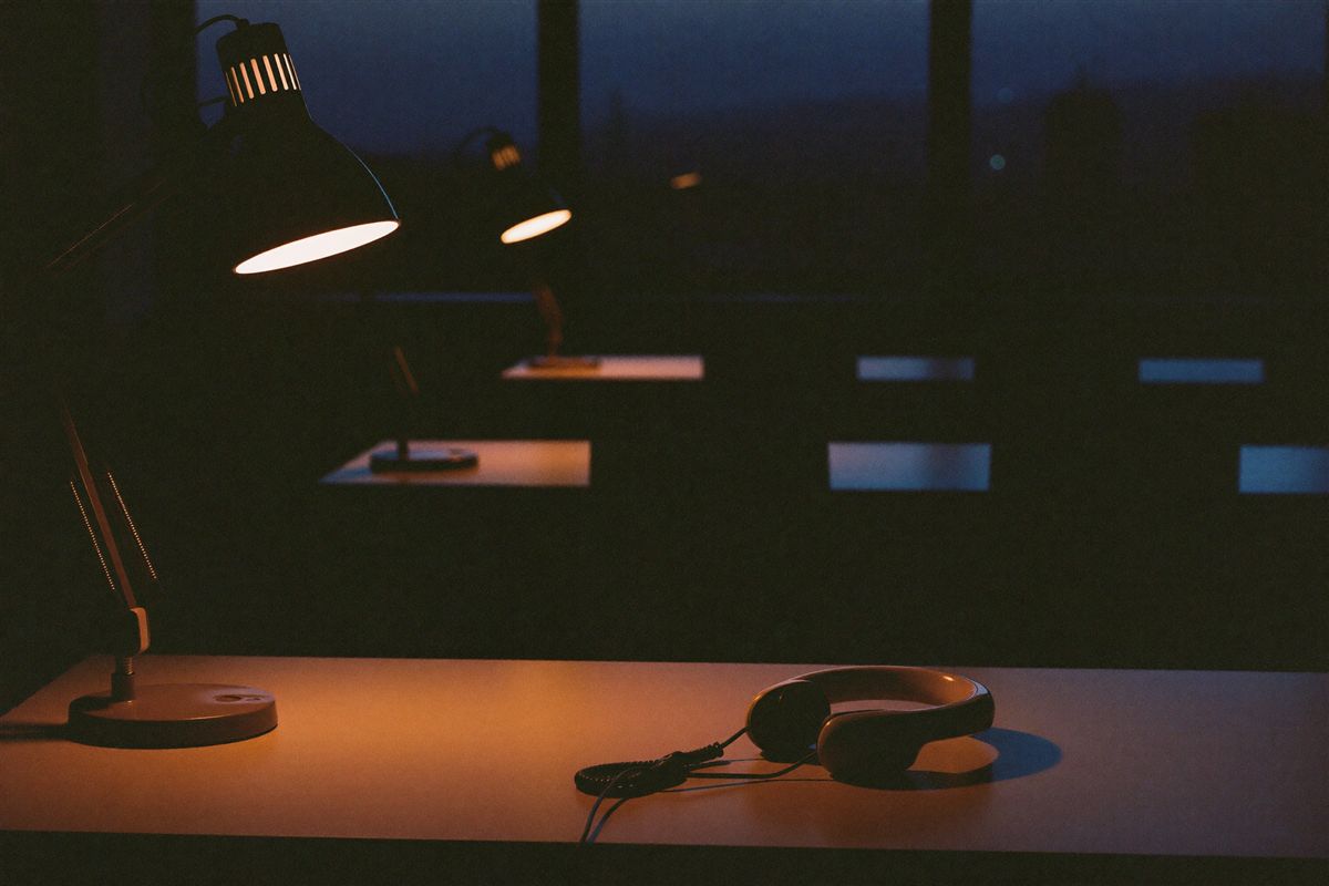Empty customer support desks lit by lamps late at night