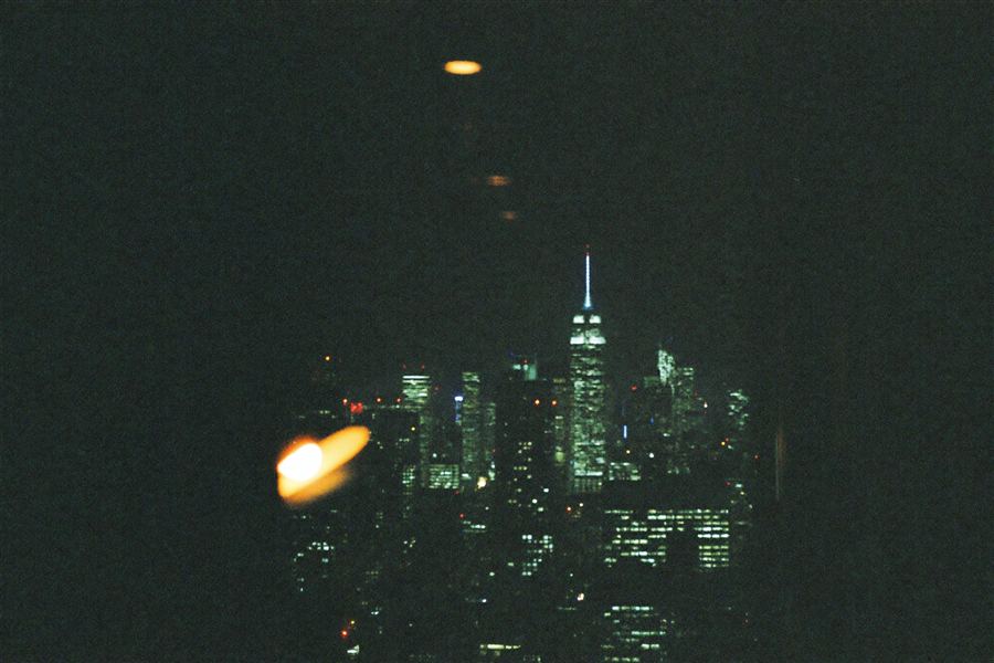 City skyline at night through a dark window