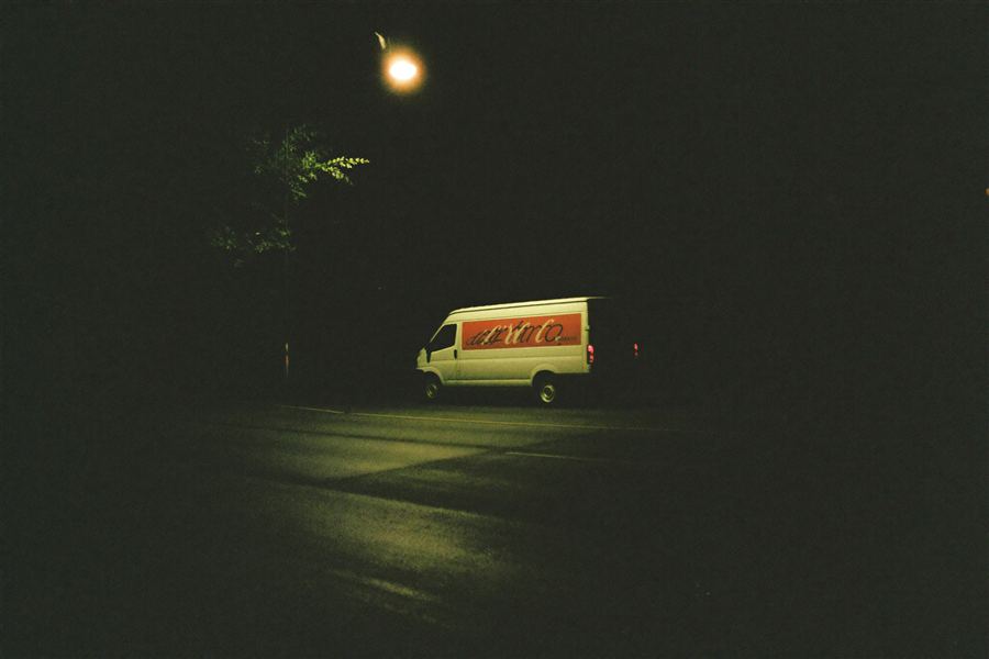Delivery van under a streetlight at night